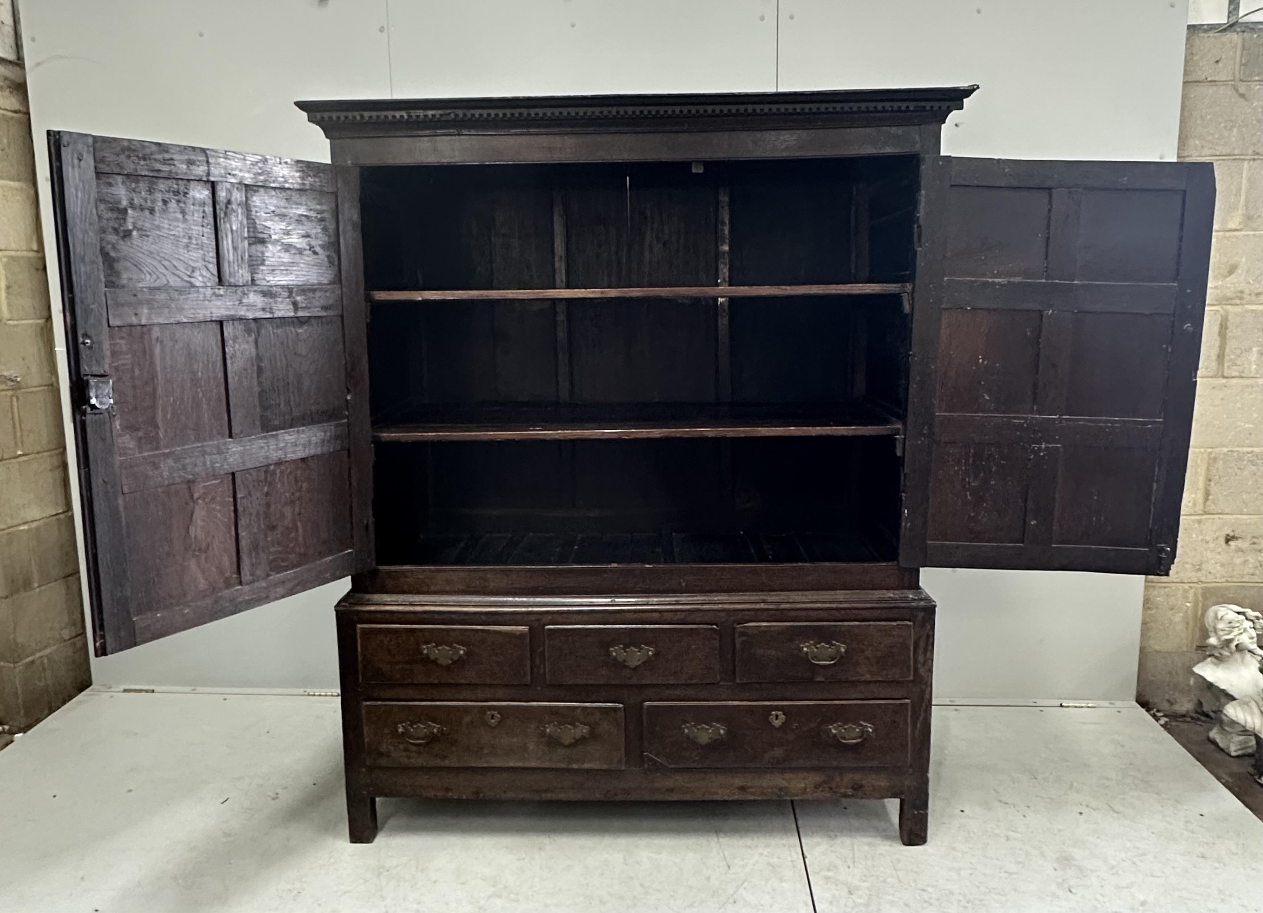 An 18th century panelled oak press cupboard, width 150cm, depth 65cm, height 183cm. Condition - poor to fair